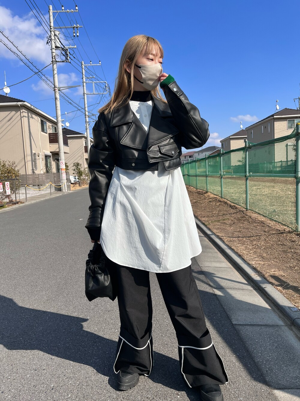 ブラック系のライダースジャケット、ホワイト系のシャツ/ブラウス、ブラック系のハンドバッグを着用したレディースの冬コーディネートの4枚目の写真