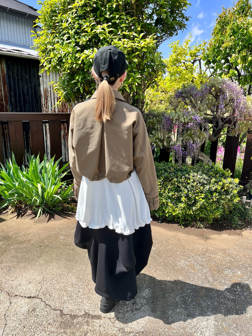 グリーン系のブルゾン、その他のタンクトップ、ブラック系のスカートを着用したレディースの春コーディネートの2枚目の写真