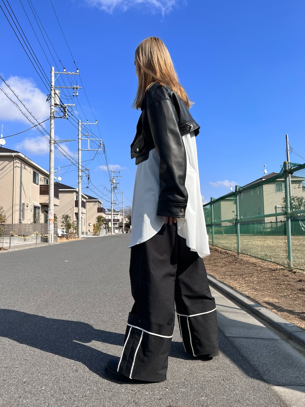 ブラック系のライダースジャケット、ホワイト系のシャツ/ブラウス、ブラック系のハンドバッグを着用したレディースの冬コーディネートの3枚目の写真