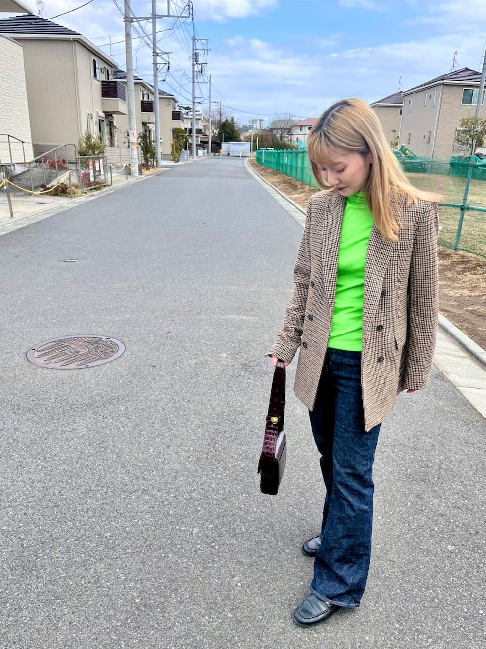 グリーン系のTシャツ/カットソー、ブラウン系のテーラードジャケット、ブルー系のデニムパンツを着用したレディースの冬コーディネートの3枚目の写真