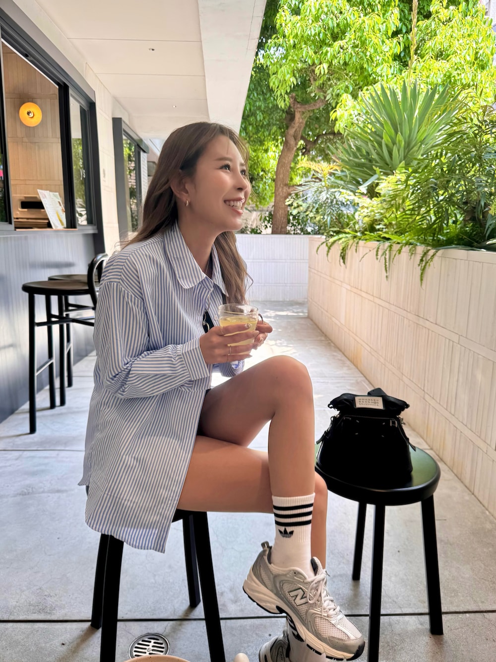 ブラック系のその他パンツ、シルバー系のスニーカー、ブラック系のショルダーバッグを着用したレディースの春コーディネートの2枚目の写真