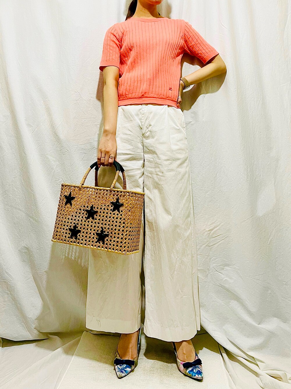 ピンク系のニット/セーター、ホワイト系のパンツ、ホワイト系のショルダーバッグを着用したレディースの春コーディネートの2枚目の写真