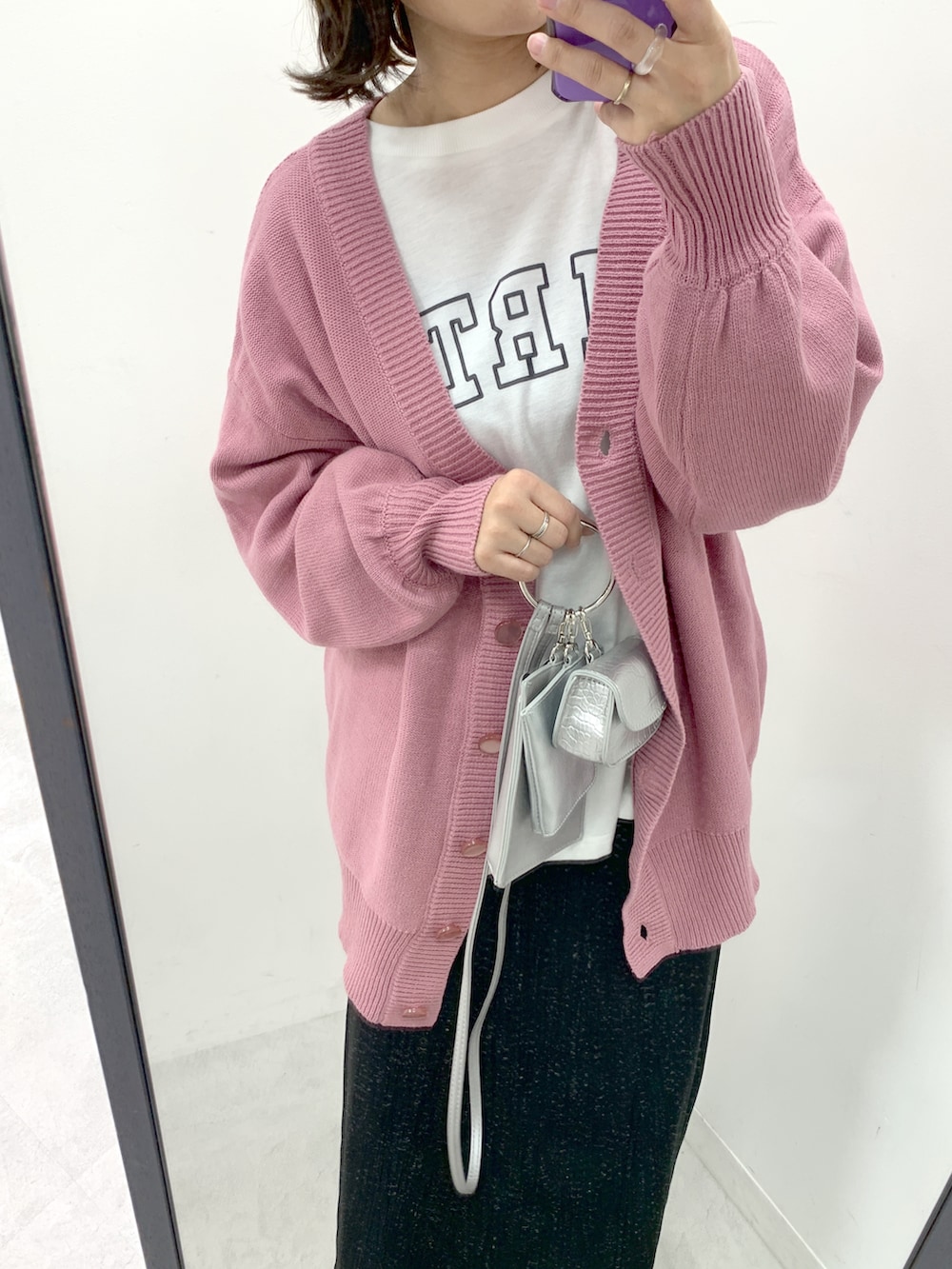 ピンク系のカーディガン/ボレロ、シルバー系のショルダーバッグ、ブラック系のスカートを着用したレディースの冬コーディネートの2枚目の写真