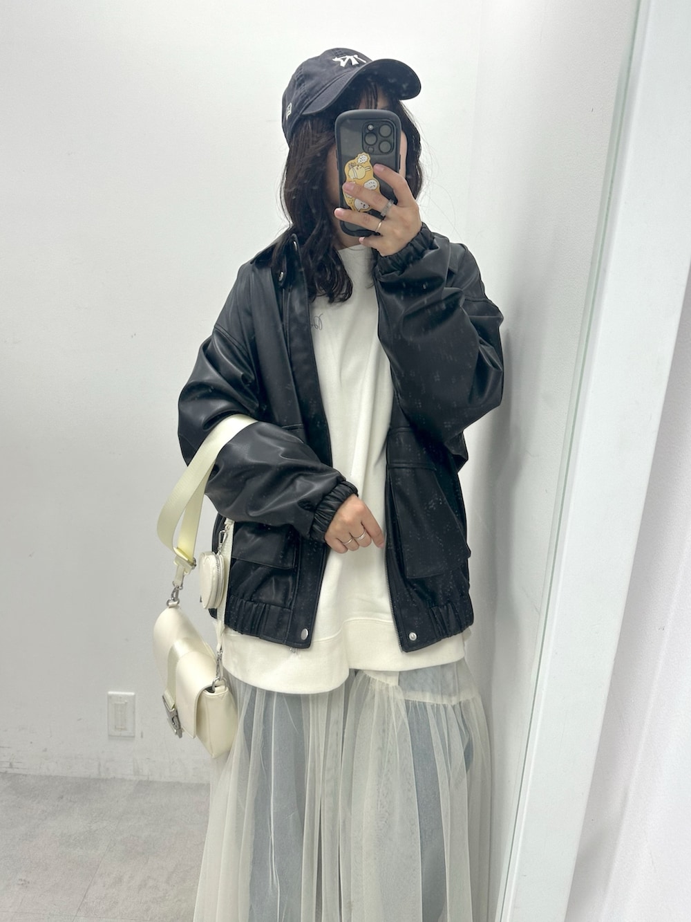 ブラック系のブルゾン、ホワイト系のスウェット、ホワイト系のショルダーバッグを着用したレディースの春コーディネートの2枚目の写真