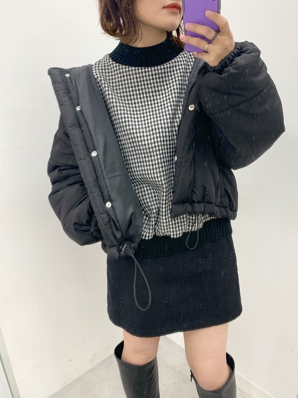 ブラック系のブーツ、ブラック系のスカート、ブラック系のTシャツ/カットソーを着用したレディースの冬コーディネートの2枚目の写真