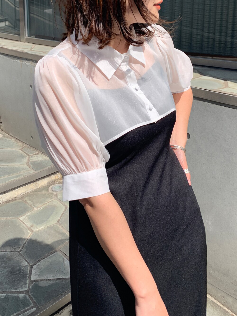 ブラック系のワンピース、ホワイト系のスニーカー、ブルー系のショルダーバッグを着用したレディースの春コーディネートの2枚目の写真