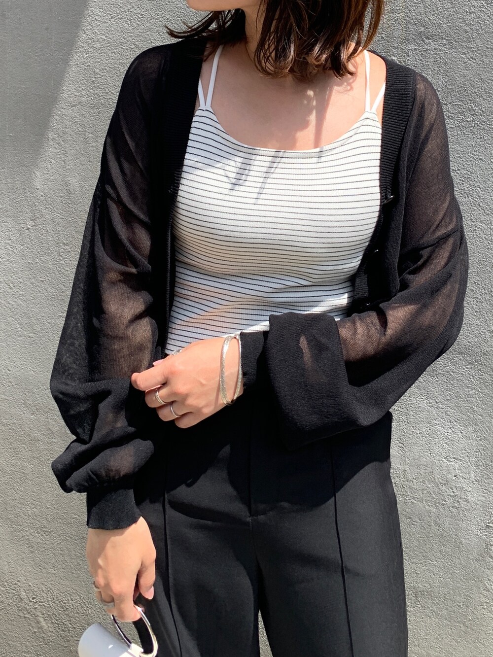 ブラック系のその他パンツ、ブラック系のカーディガン/ボレロ、ホワイト系のサンダルを着用したレディースの春コーディネートの2枚目の写真