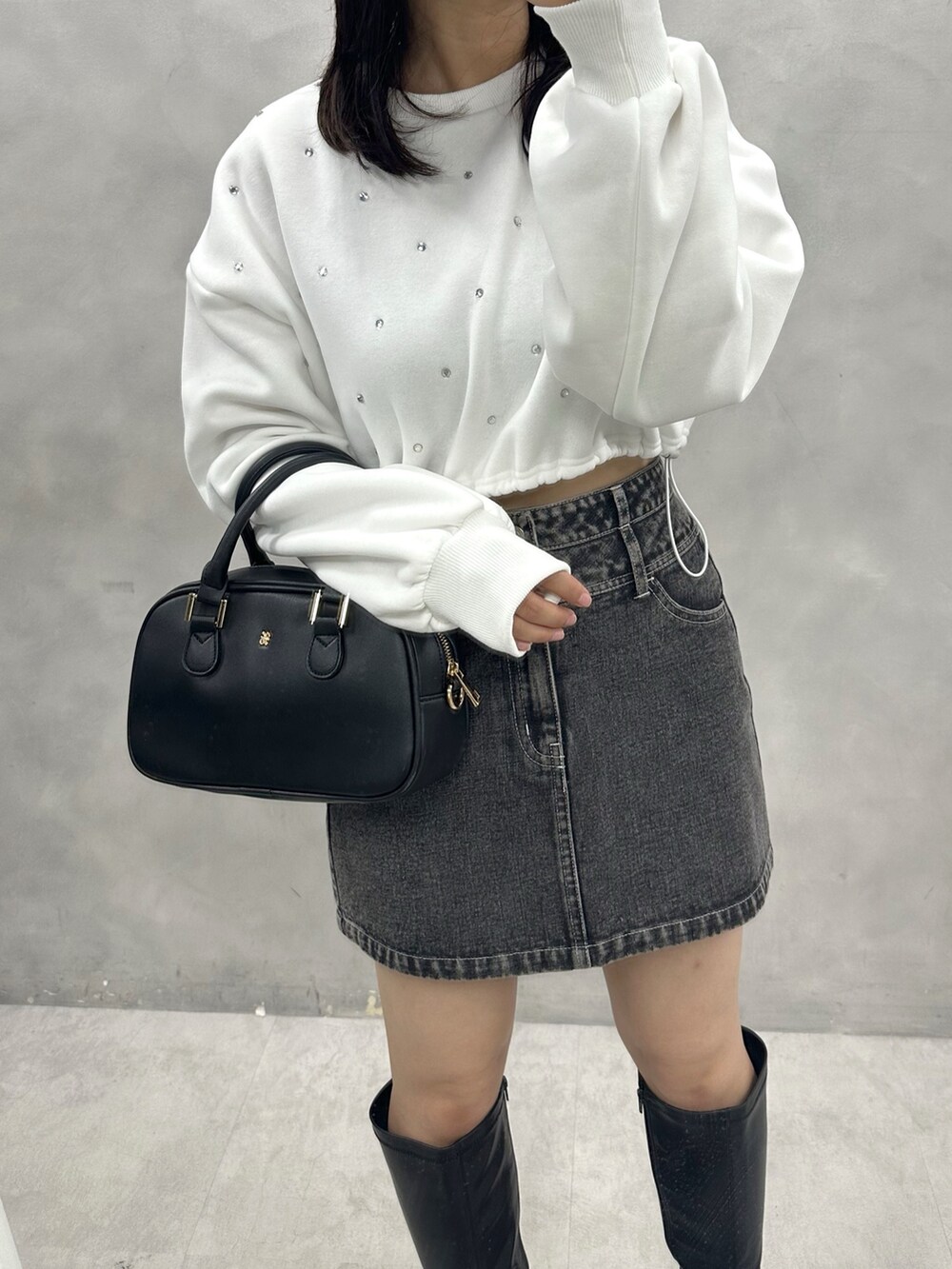 ブラック系のスカート、ブラック系のショルダーバッグ、ホワイト系のスウェットを着用したレディースの秋コーディネートの2枚目の写真