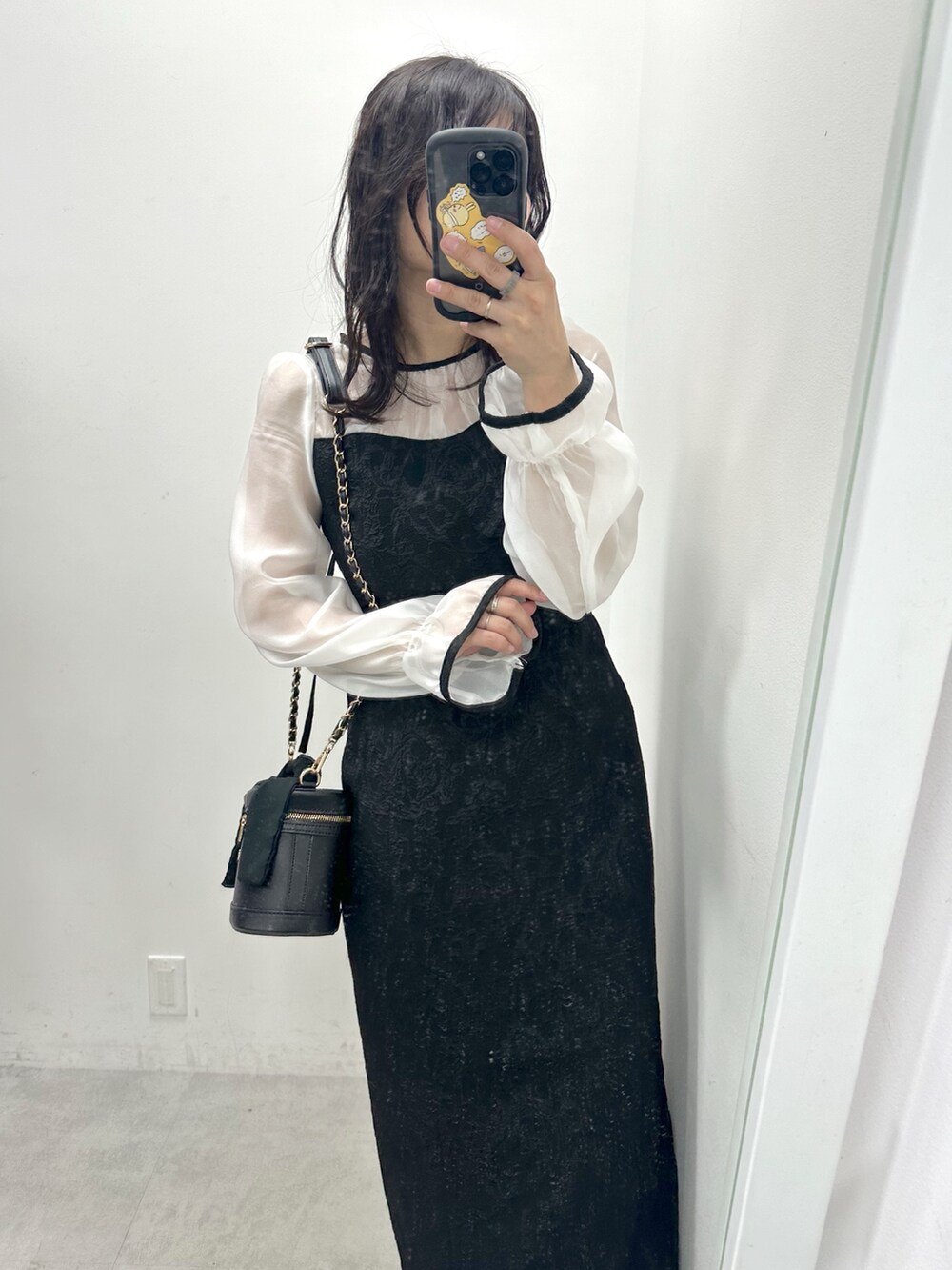 ブラック系のドレスを着用したレディースの冬コーディネートの2枚目の写真