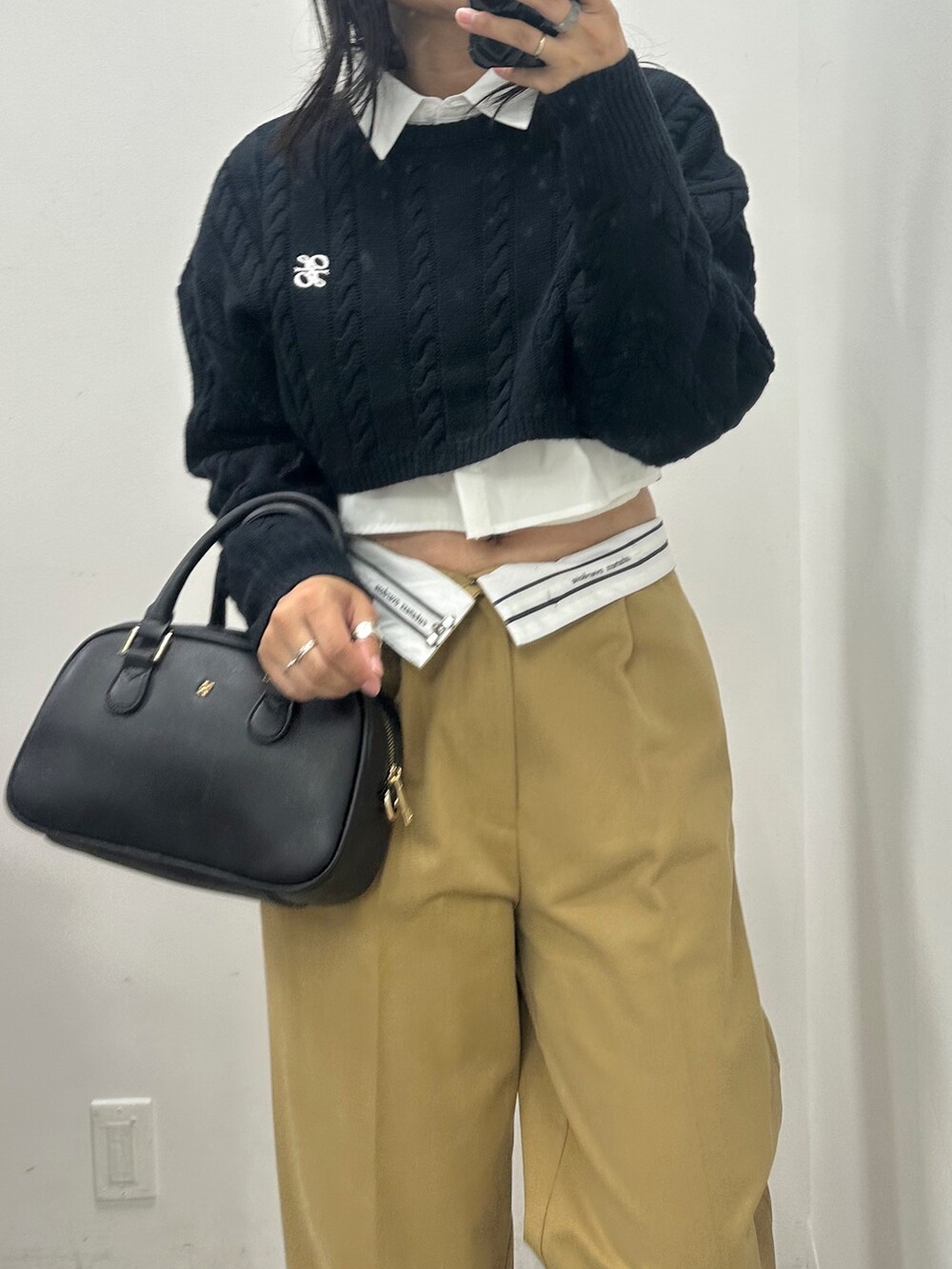 イエロー系のスラックス、ブルー系のニット/セーター、ブラック系のショルダーバッグを着用したレディースの秋コーディネートの2枚目の写真