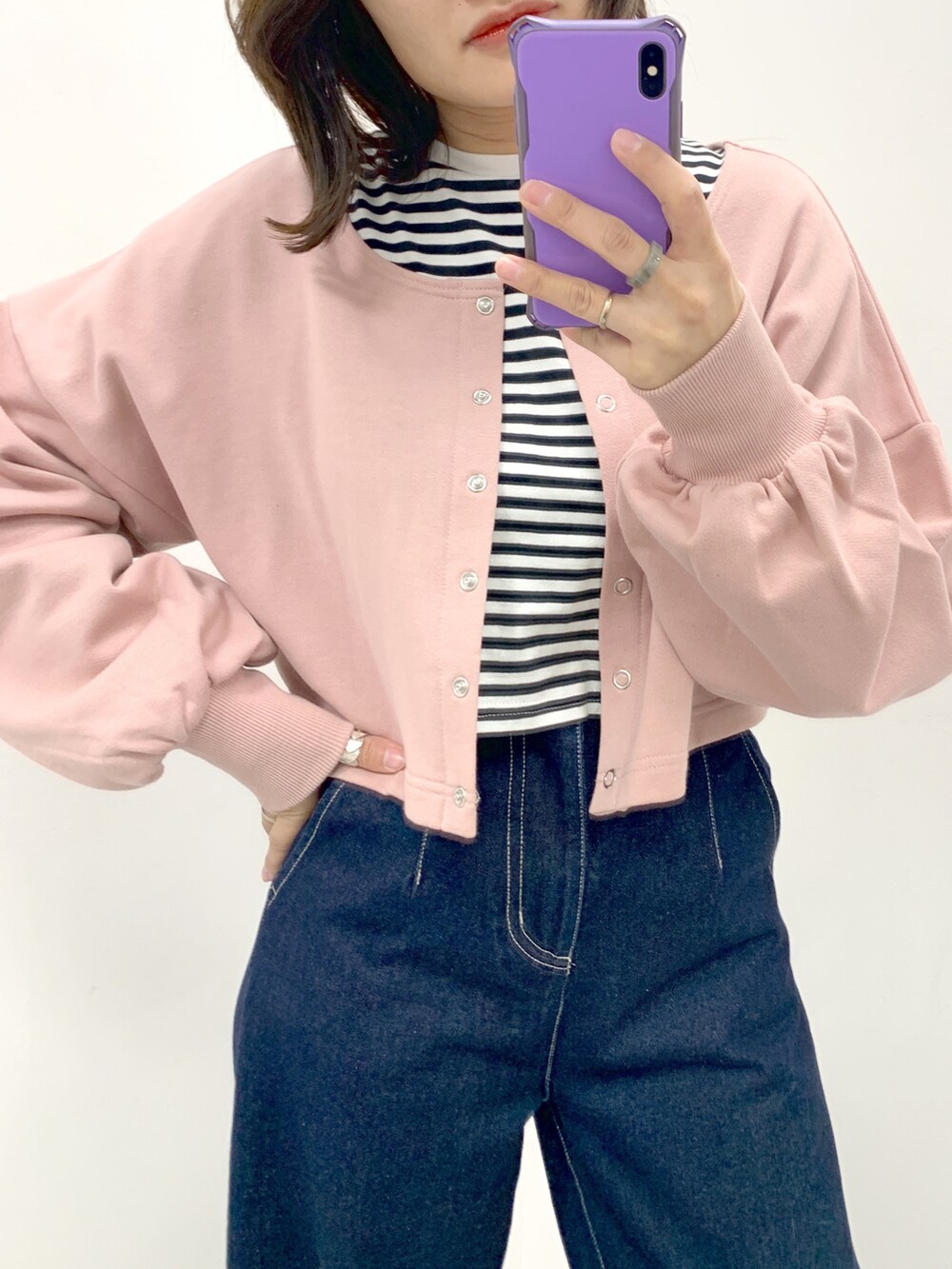 ブルー系のデニムパンツ、ピンク系のカーディガン/ボレロ、ブラック系のTシャツ/カットソーを着用したレディースの春コーディネートの2枚目の写真