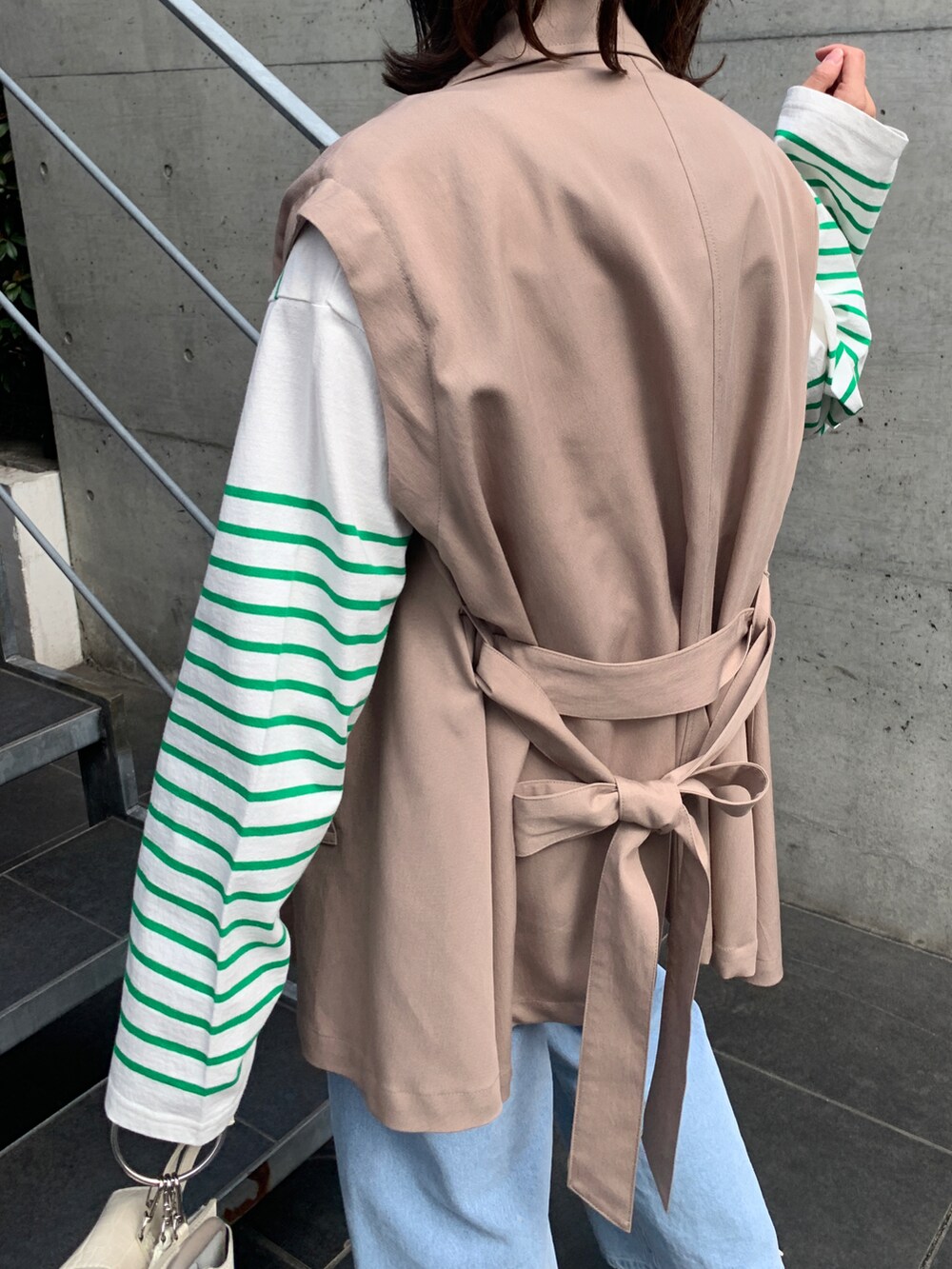 ホワイト系のサンダル、ブルー系のその他パンツ、ベージュ系のトレンチコートを着用したレディースの春コーディネートの3枚目の写真