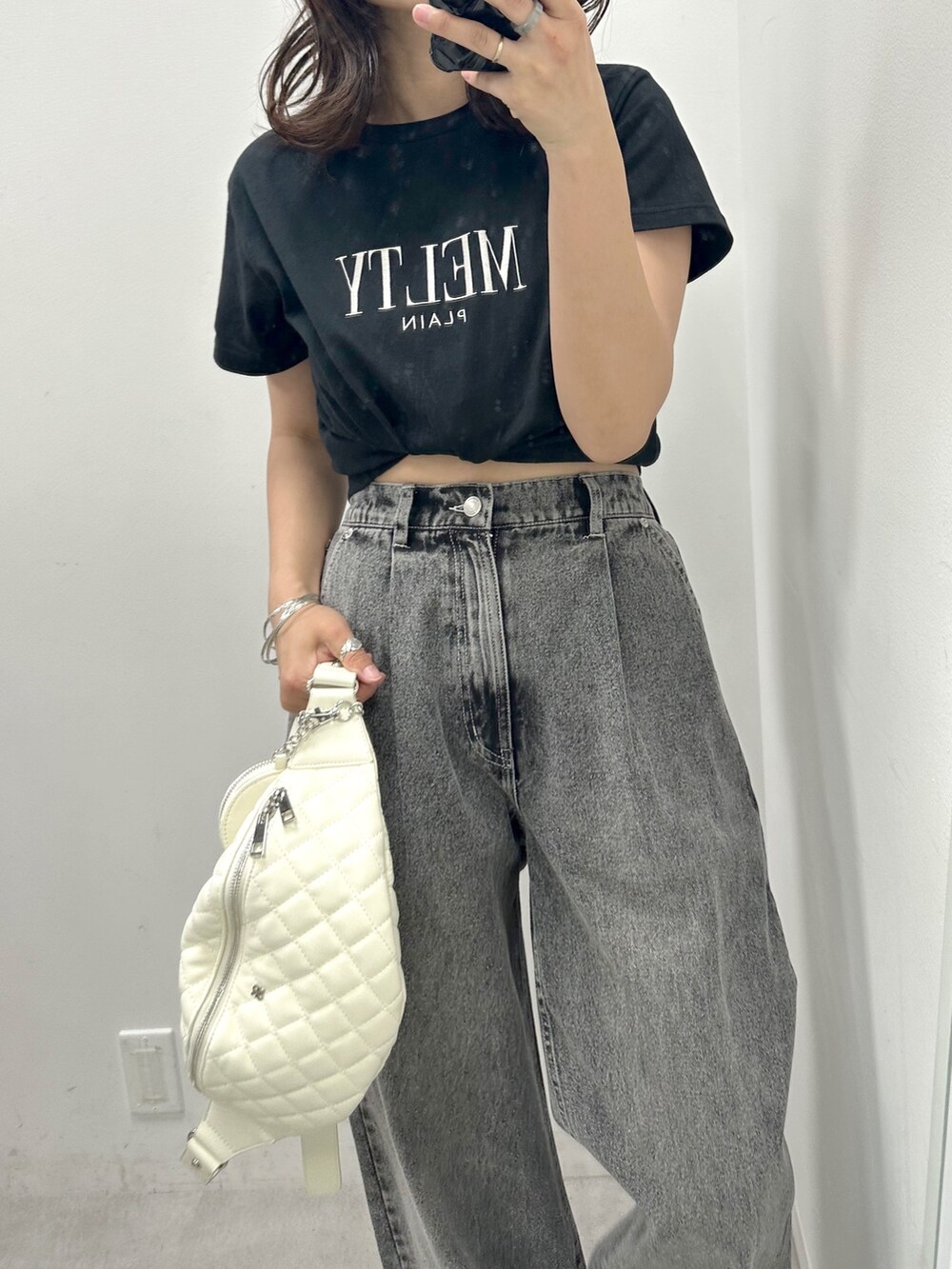 ブラック系のデニムパンツ、ブラック系のTシャツ/カットソー、ホワイト系のボディバッグ/ウエストポーチを着用したレディースの夏コーディネートの2枚目の写真