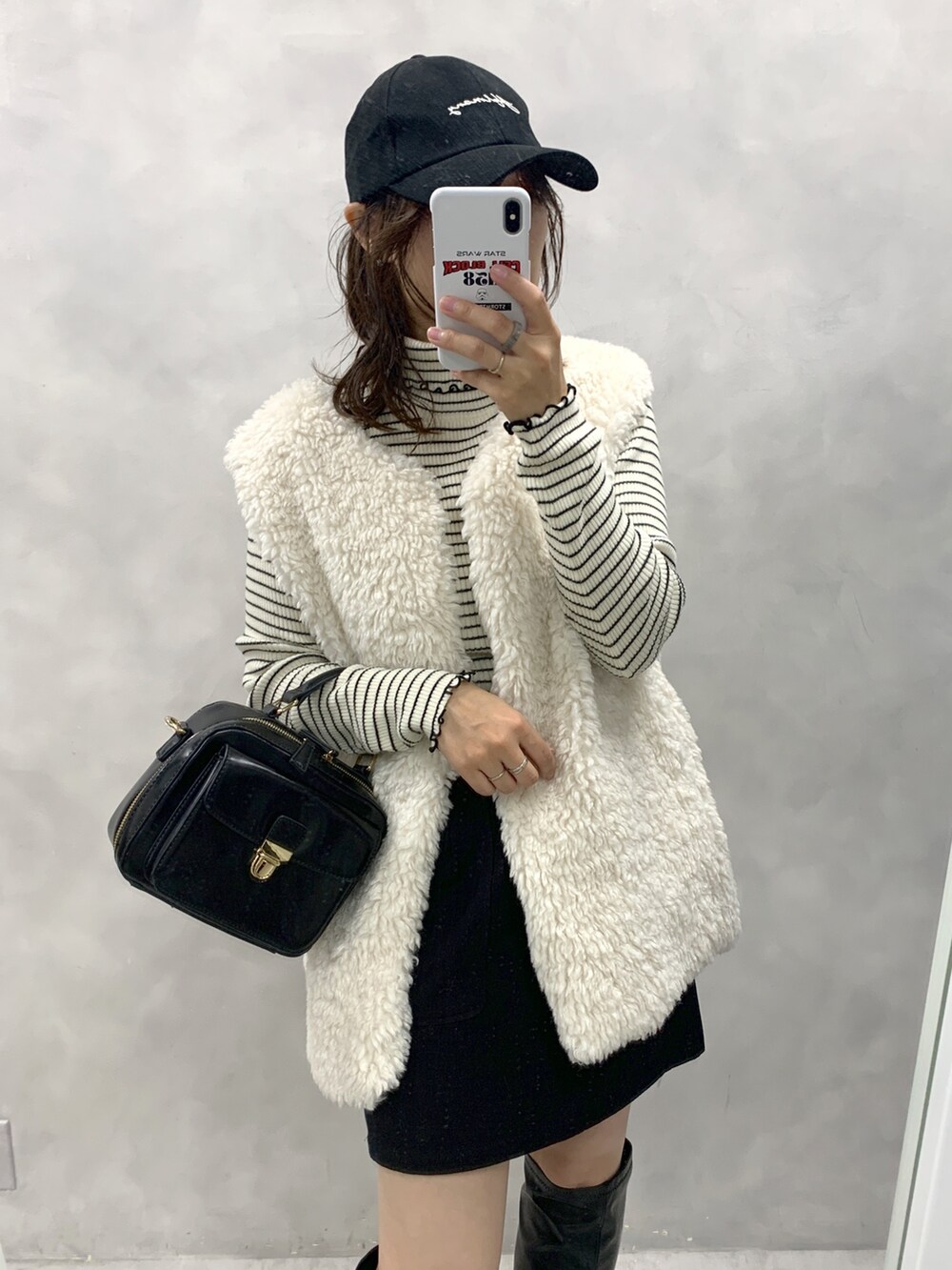 ブラック系のスカート、ホワイト系のベスト、ホワイト系のニット/セーターを着用したレディースの秋コーディネートの2枚目の写真