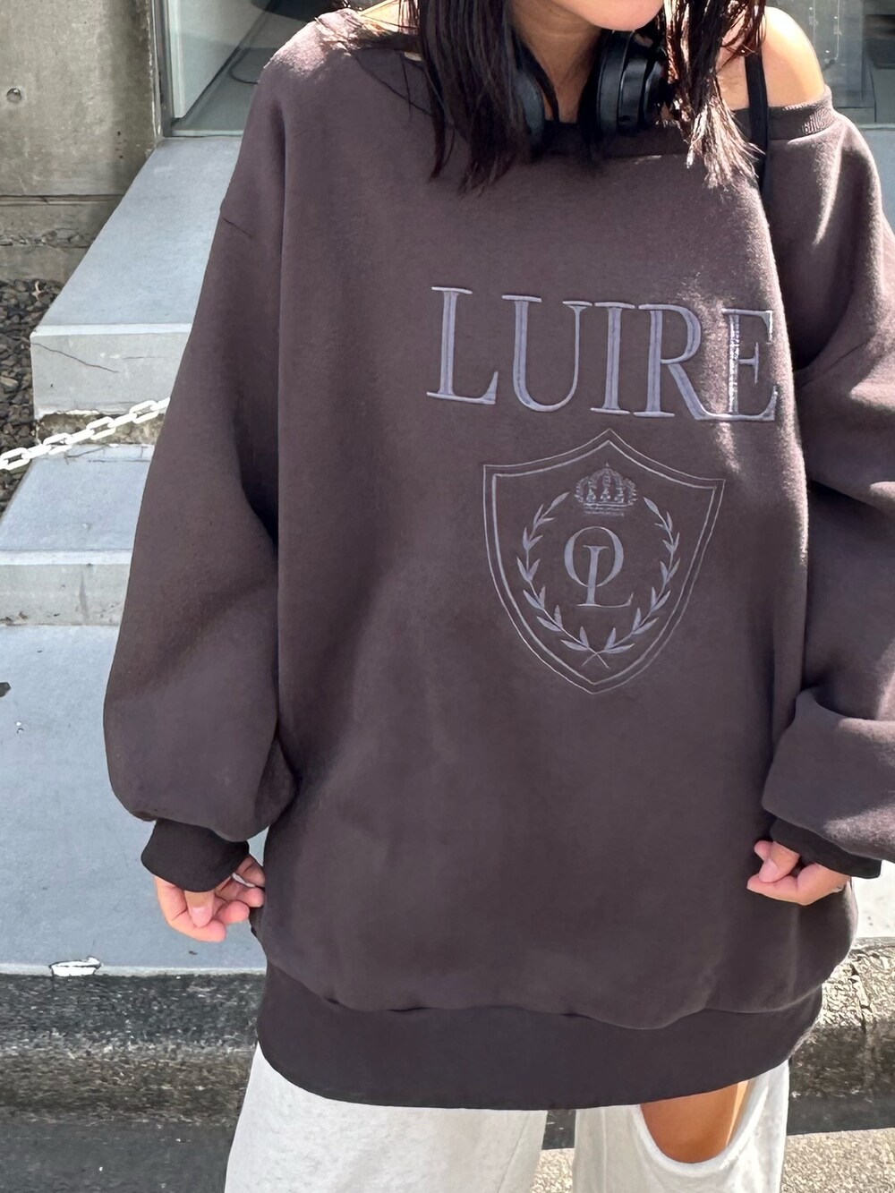 グレー系のスウェット、ホワイト系のスニーカーを着用したレディースの秋コーディネートの2枚目の写真