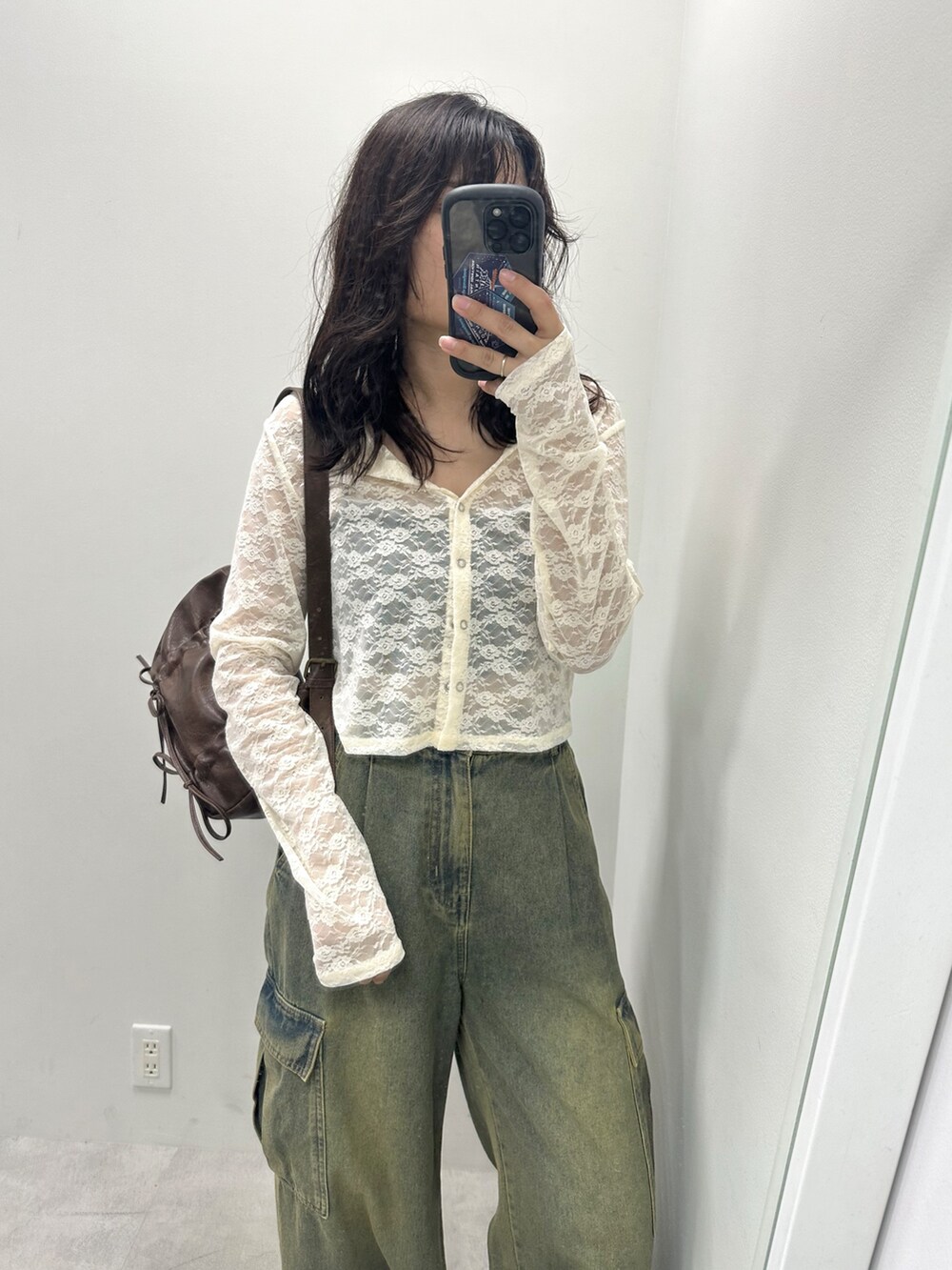 ブルー系のデニムパンツ、ブラウン系のショルダーバッグ、ホワイト系のカーディガン/ボレロを着用したレディースの夏コーディネートの2枚目の写真