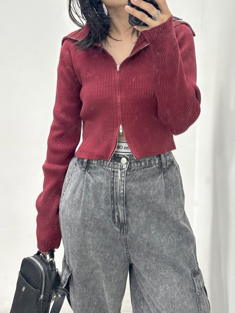 ブラック系のカーゴパンツ、レッド系のニット/セーター、ブラック系のショルダーバッグを着用したレディースの秋コーディネートの2枚目の写真