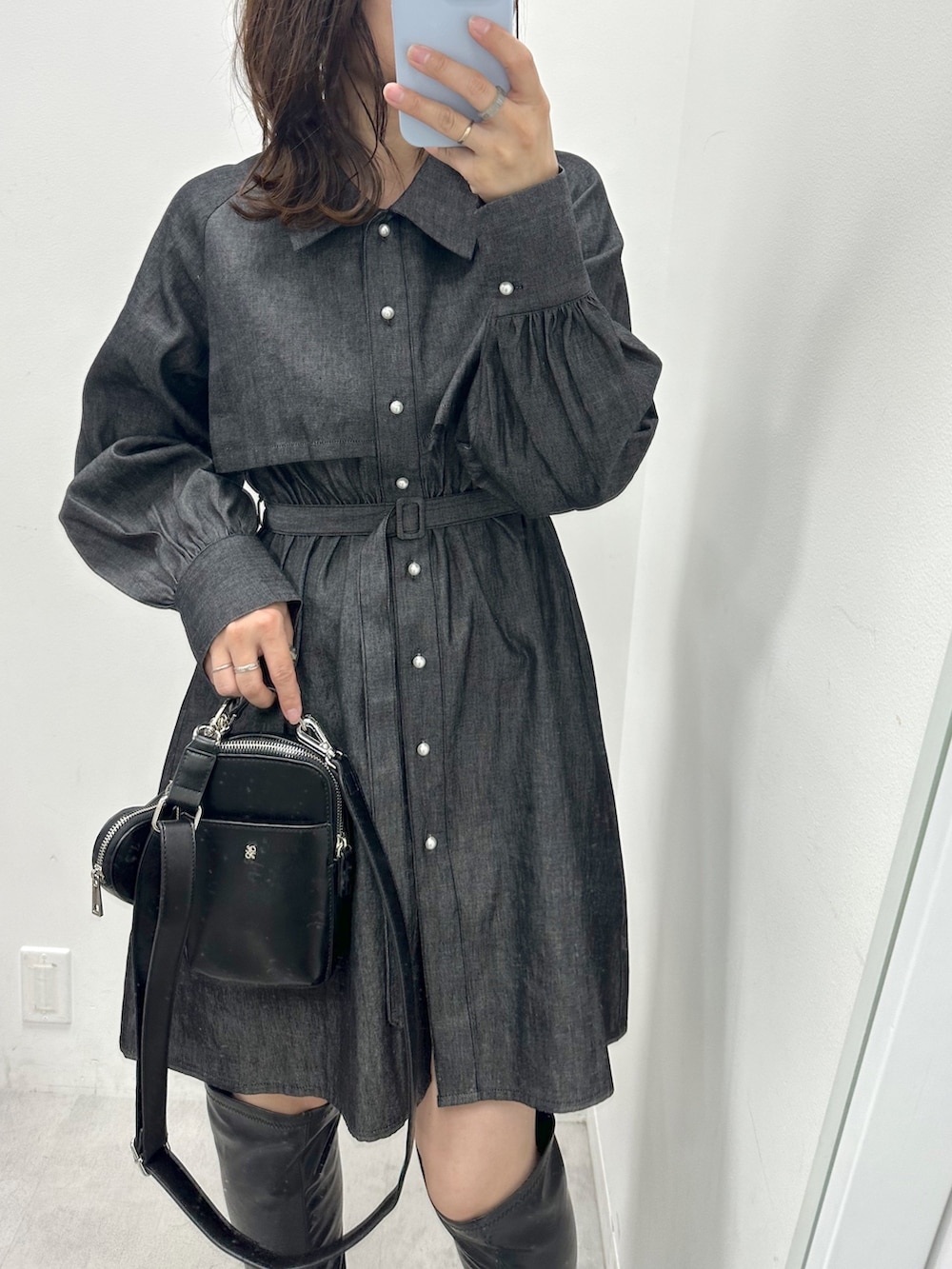 ブラック系のワンピース、ブラック系のショルダーバッグ、ブラック系のブーツを着用したレディースの冬コーディネートの2枚目の写真