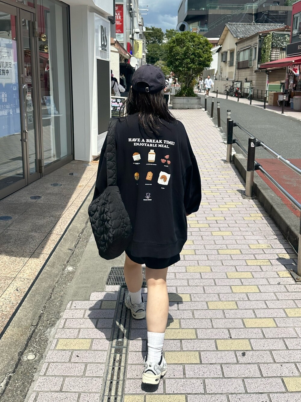 ブラック系のスウェット、ブラック系のショルダーバッグ、シルバー系のスニーカーを着用したレディースの秋コーディネートの2枚目の写真