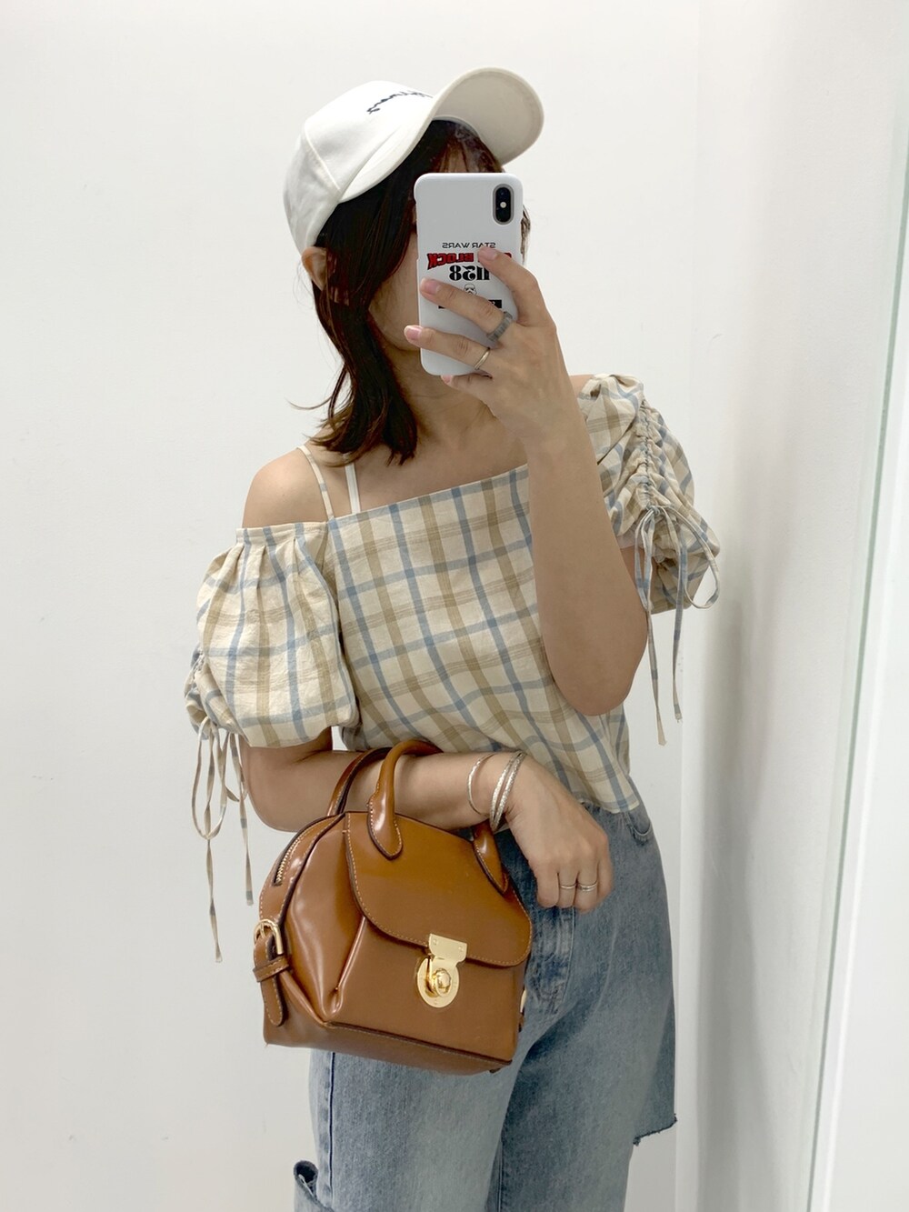 ブルー系のデニムパンツ、ベージュ系のシャツ/ブラウス、ホワイト系のショルダーバッグを着用したレディースの夏コーディネートの2枚目の写真