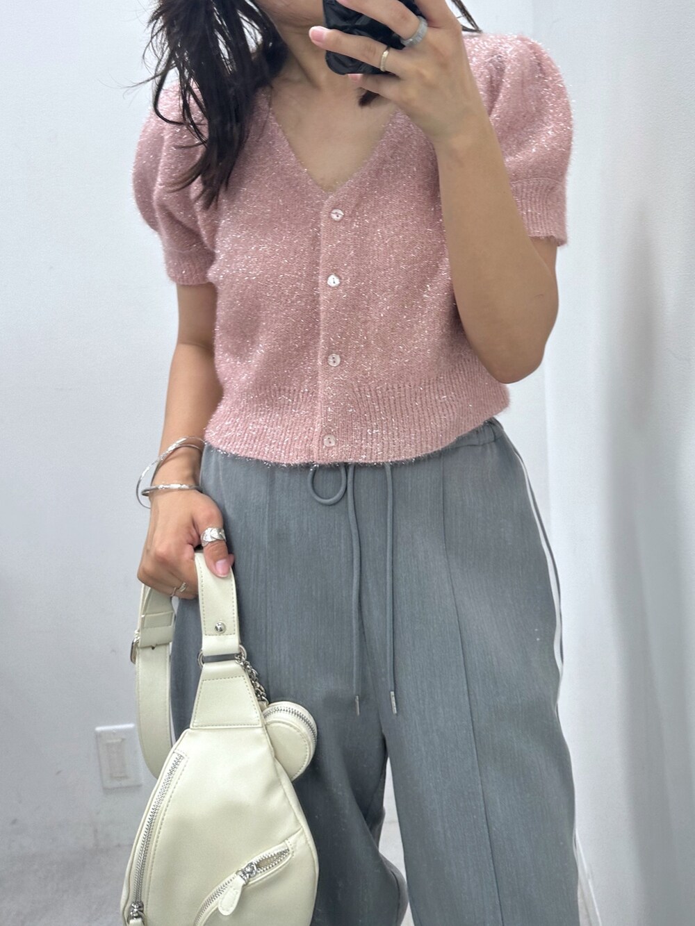 グレー系のその他パンツ、ピンク系のカーディガン/ボレロ、ホワイト系のボディバッグ/ウエストポーチを着用したレディースの夏コーディネートの2枚目の写真