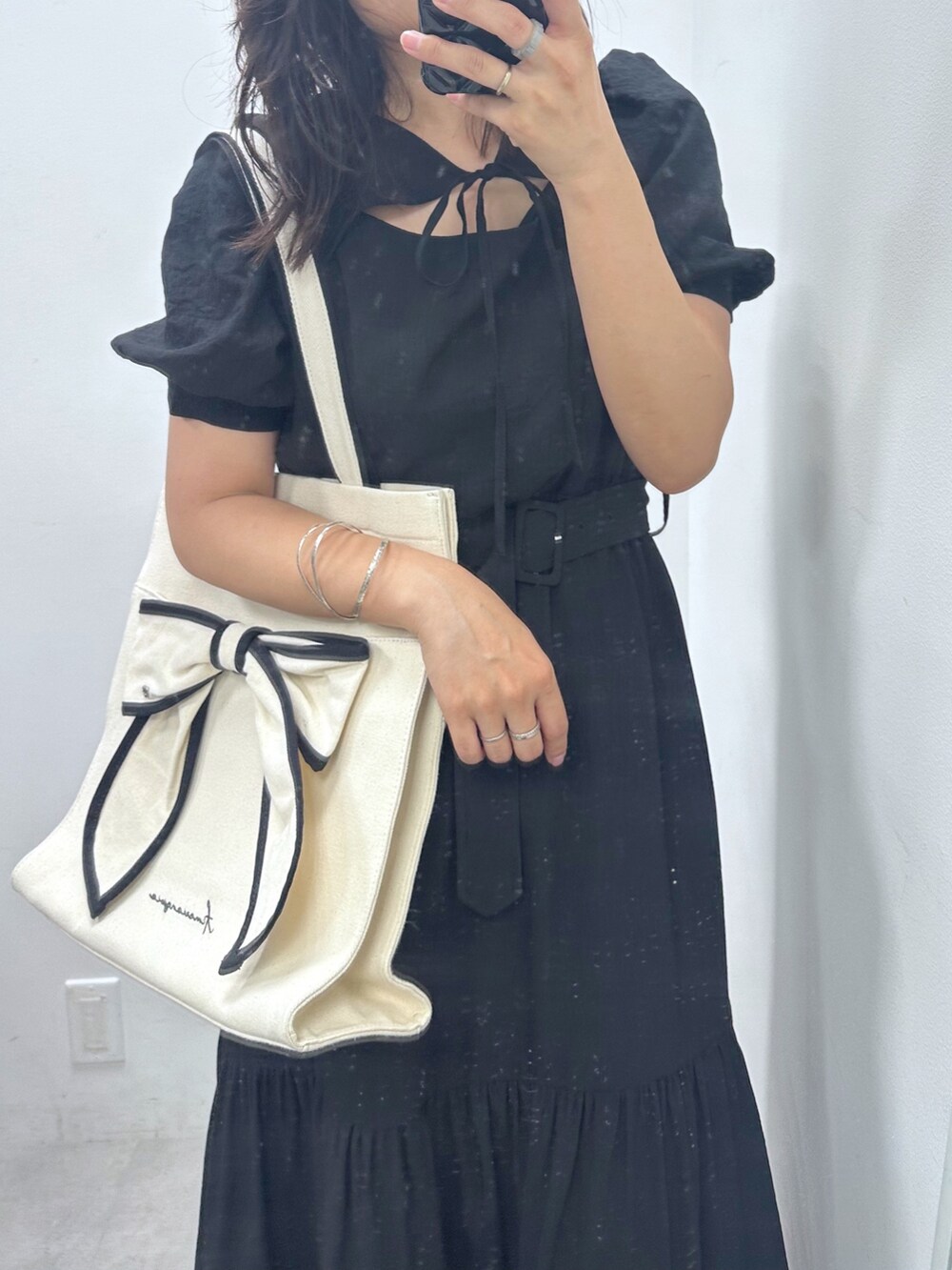 ブラック系のワンピース、ブラック系のトートバッグ、ブラック系のブーツを着用したレディースの夏コーディネートの2枚目の写真