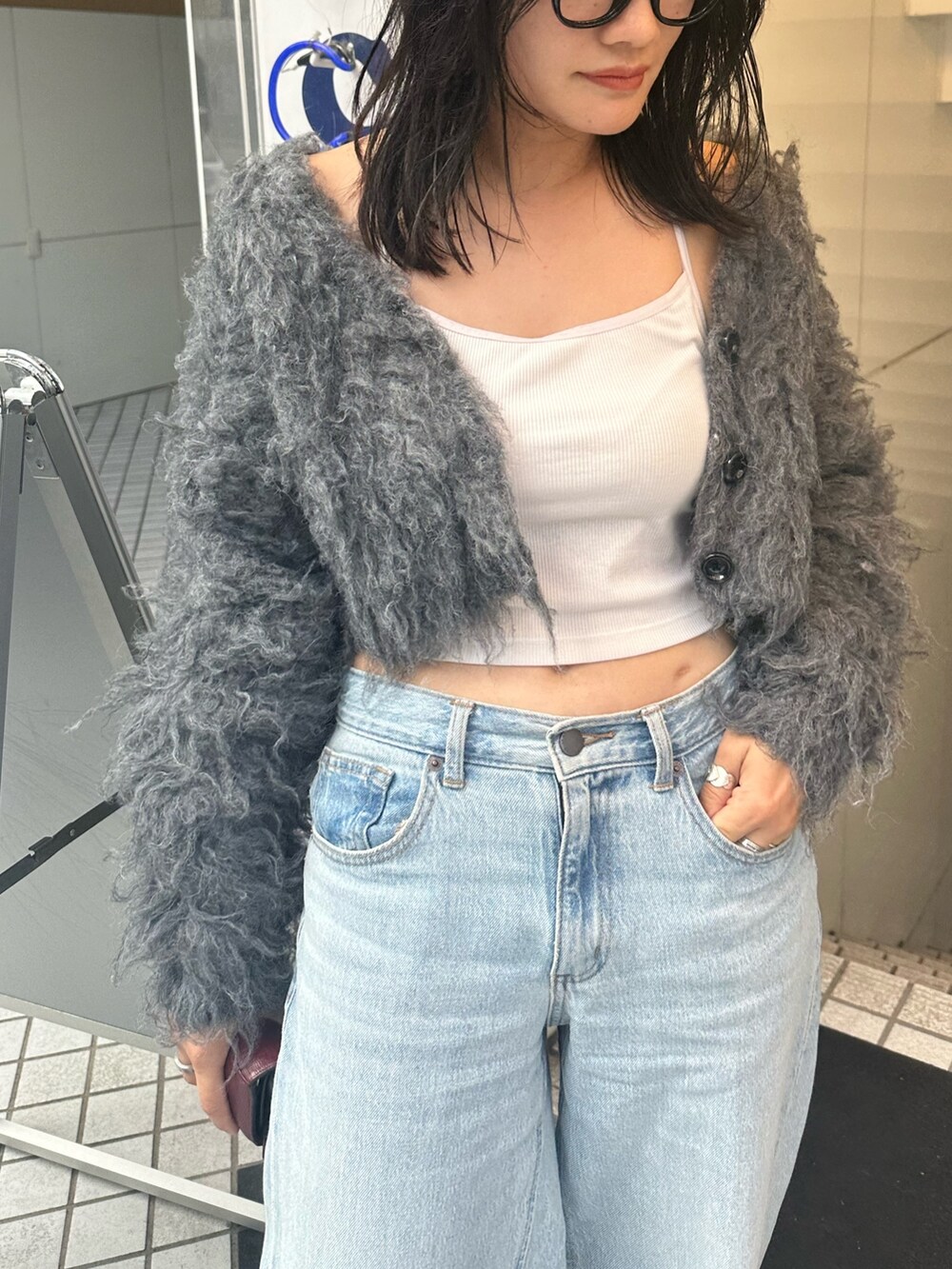 グレー系のカーディガン/ボレロ、ホワイト系のスニーカーを着用したレディースの秋コーディネートの2枚目の写真