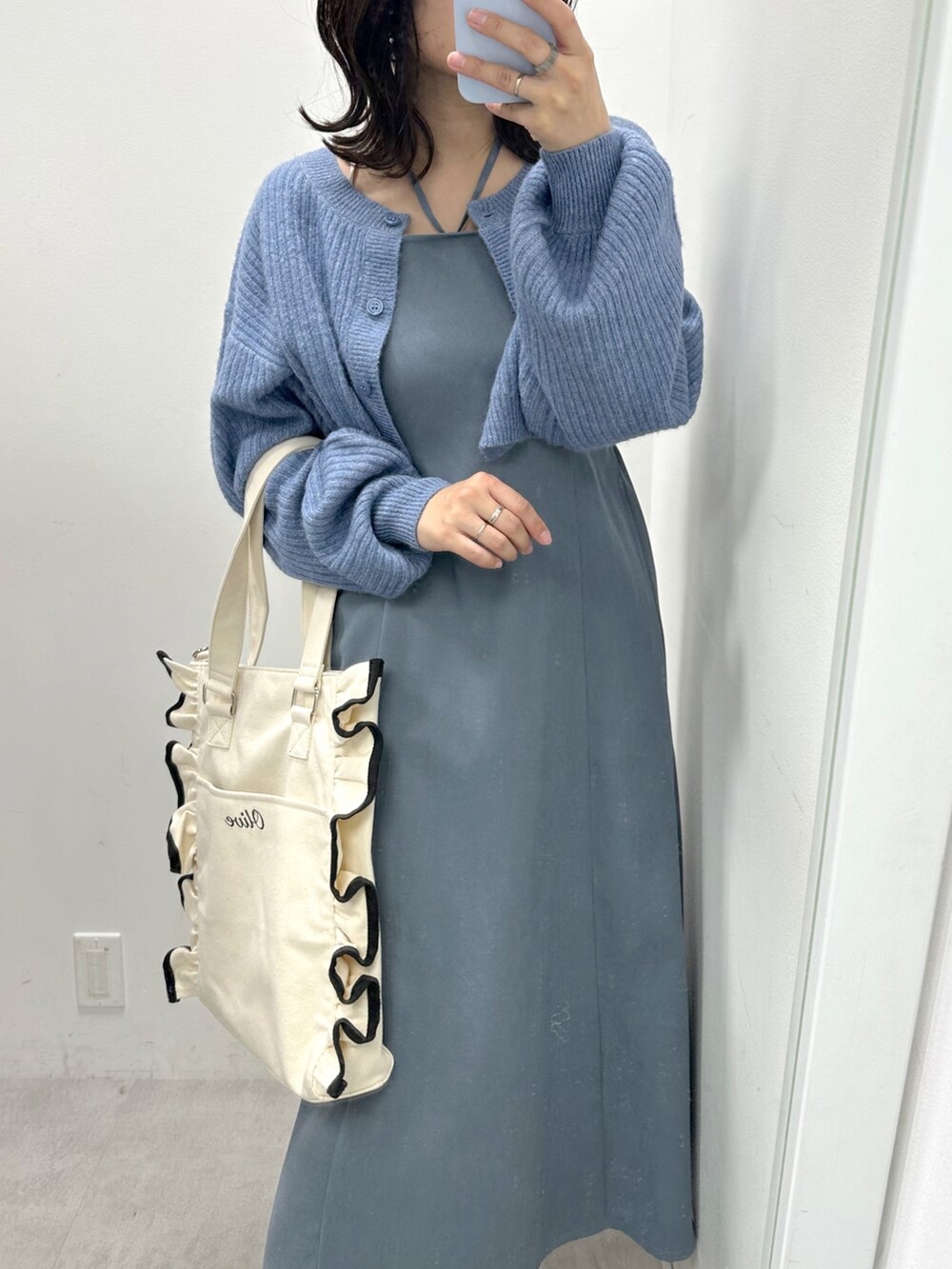 ブルー系のワンピース、ホワイト系のトートバッグ、ホワイト系のスニーカーを着用したレディースの冬コーディネートの2枚目の写真