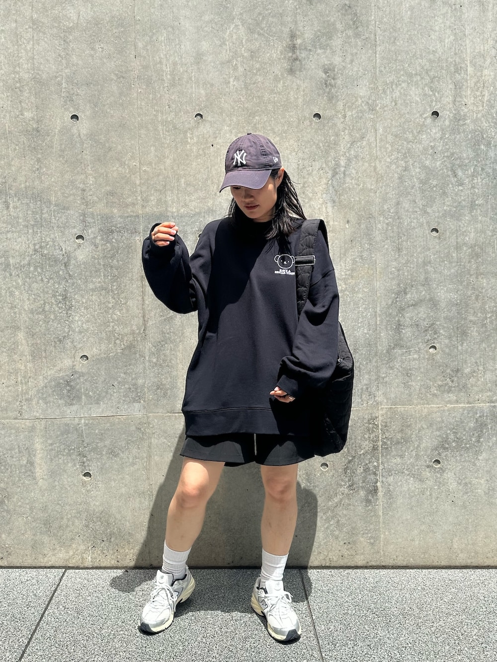 ブラック系のスウェット、ブラック系のショルダーバッグ、シルバー系のスニーカーを着用したレディースの秋コーディネートの3枚目の写真