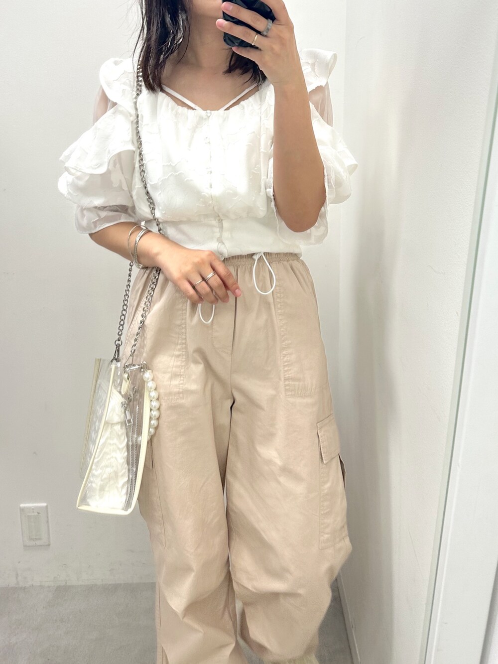 ホワイト系のカーゴパンツ、ホワイト系のシャツ/ブラウス、ホワイト系のショルダーバッグを着用したレディースの春コーディネートの2枚目の写真