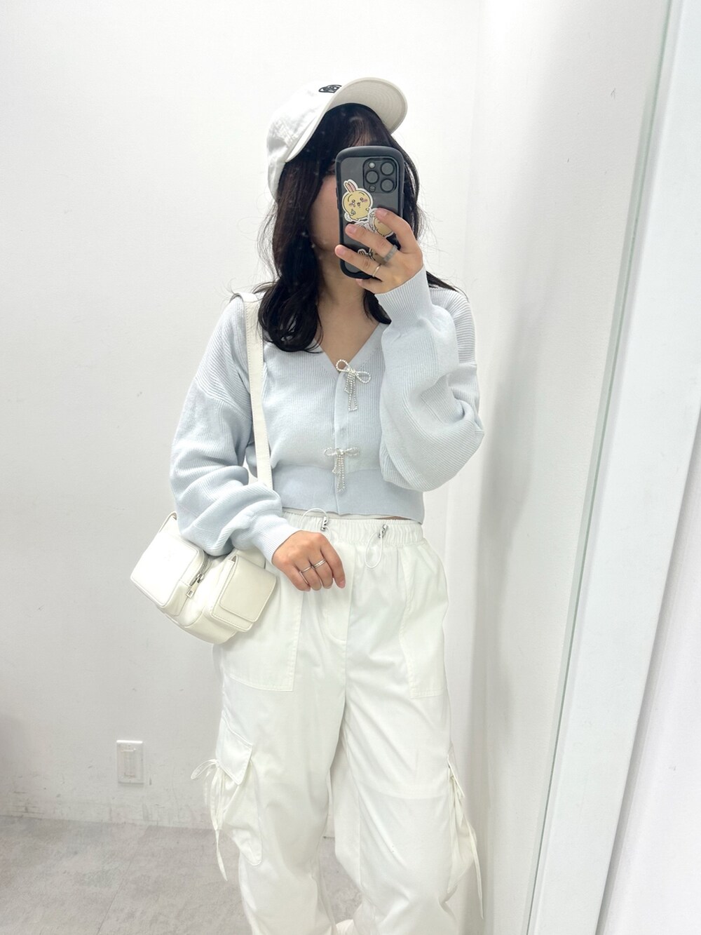 ホワイト系のカーゴパンツ、ブルー系のカーディガン/ボレロ、ホワイト系のショルダーバッグを着用したレディースの春コーディネートの2枚目の写真