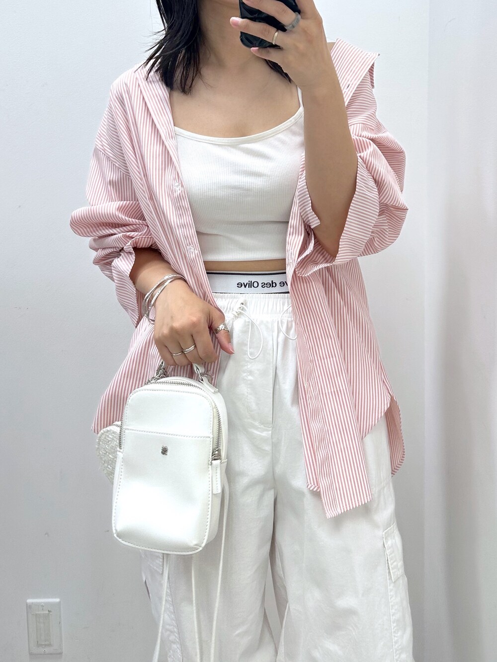 ホワイト系のカーゴパンツ、ピンク系のシャツ/ブラウス、ホワイト系のショルダーバッグを着用したレディースの夏コーディネートの2枚目の写真
