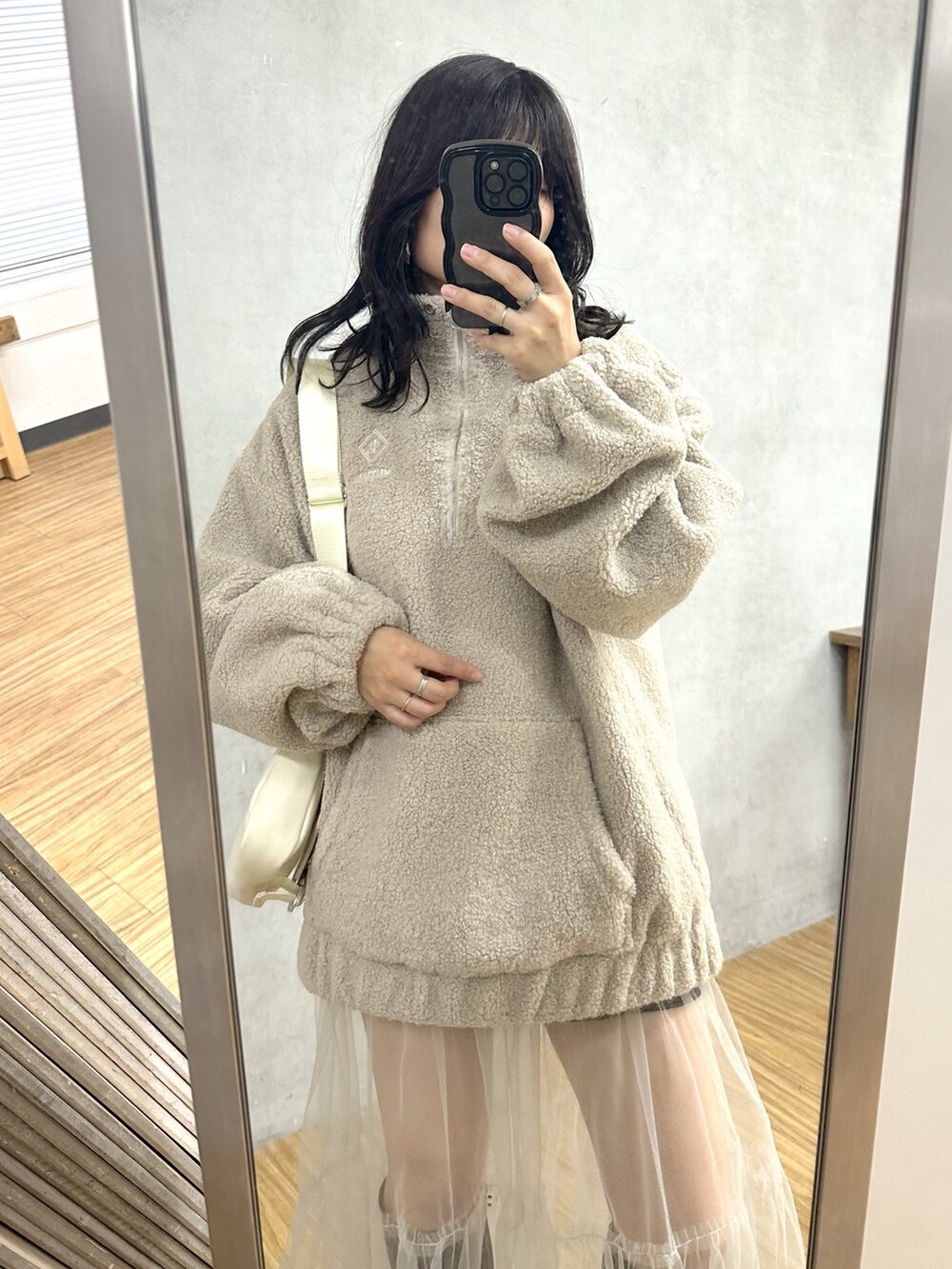 ベージュ系のブルゾン、ホワイト系のショルダーバッグ、グリーン系のワンピースを着用したレディースの冬コーディネートの2枚目の写真