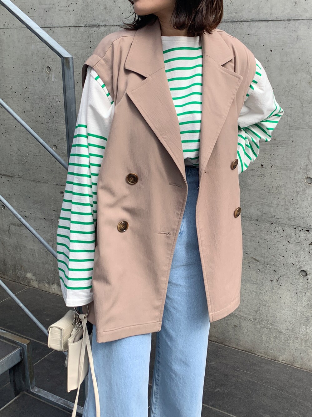 ホワイト系のサンダル、ブルー系のその他パンツ、ベージュ系のトレンチコートを着用したレディースの春コーディネートの2枚目の写真