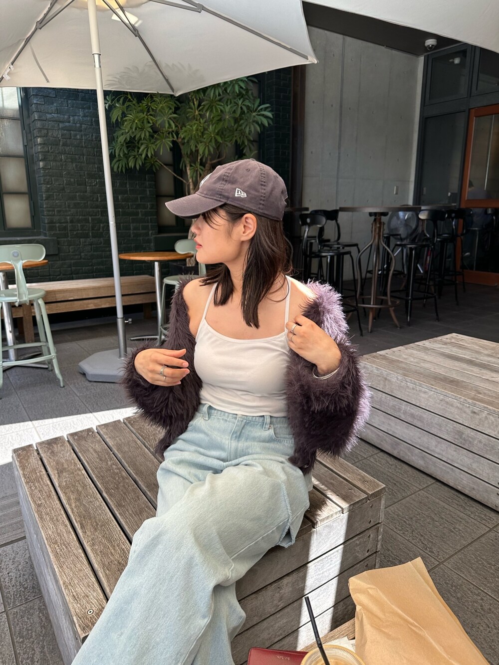 ブルー系のデニムパンツ、グレー系のカーディガン/ボレロ、ブルー系のキャップを着用したレディースの秋コーディネートの2枚目の写真