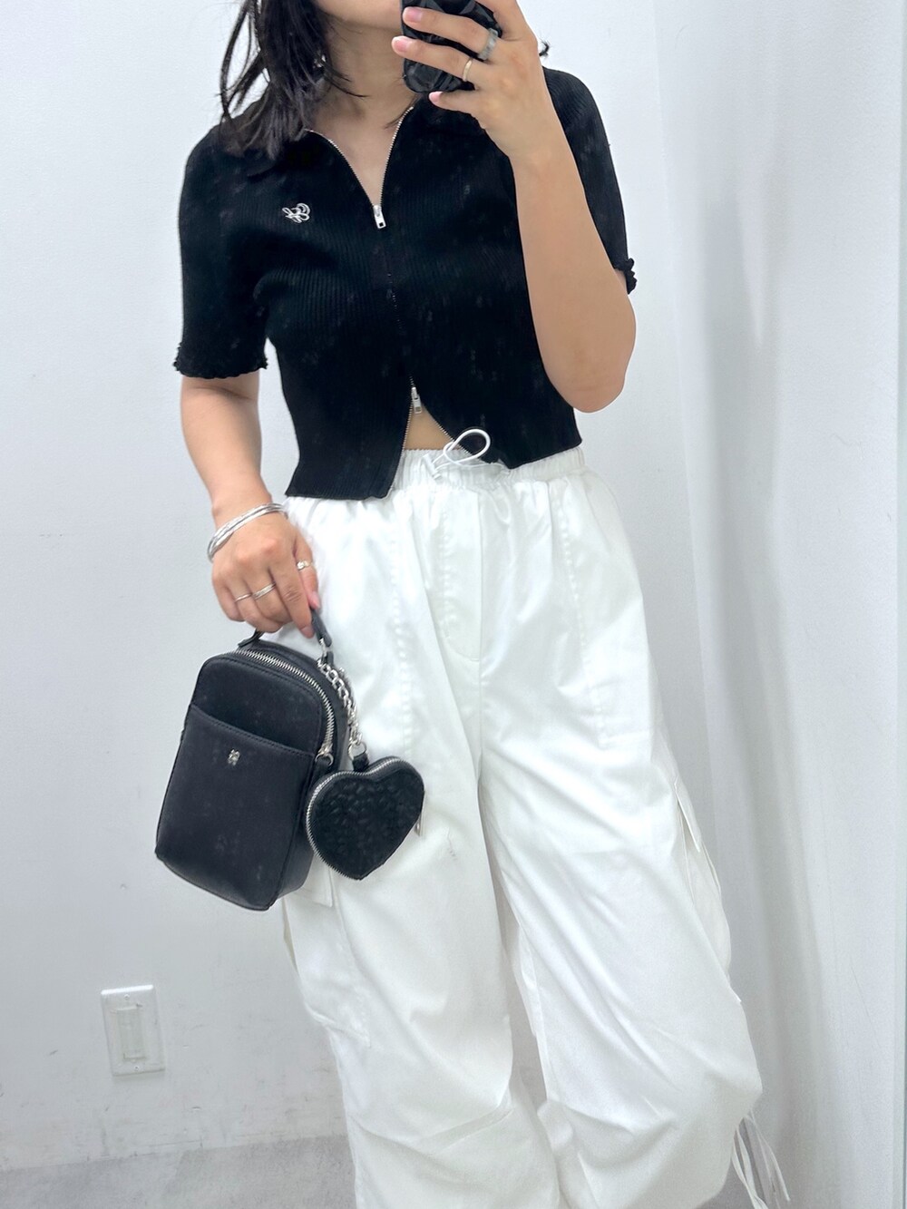 ブラック系のTシャツ/カットソー、ブラック系のショルダーバッグ、ホワイト系のサンダルを着用したレディースの夏コーディネートの2枚目の写真