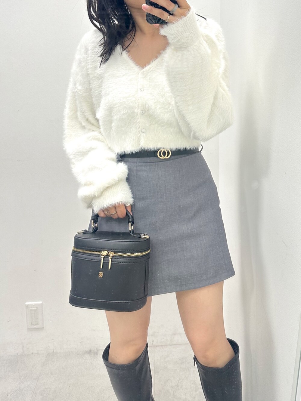 グレー系のスカート、ホワイト系のカーディガン/ボレロ、ブラック系のショルダーバッグを着用したレディースの夏コーディネートの2枚目の写真