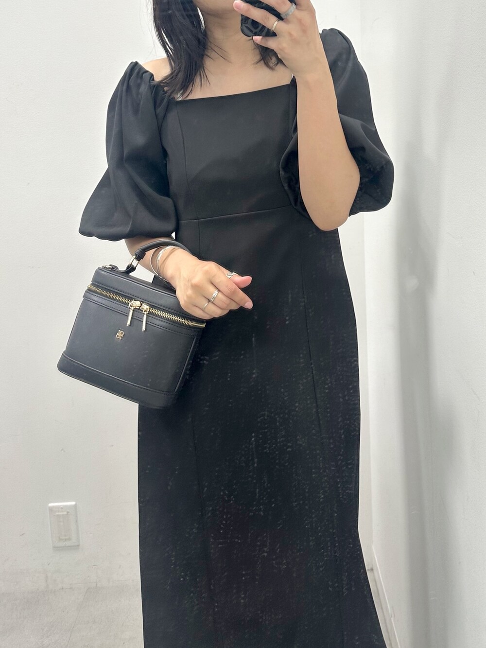 ブラック系のワンピース、ホワイト系のサンダルを着用したレディースの夏コーディネートの2枚目の写真