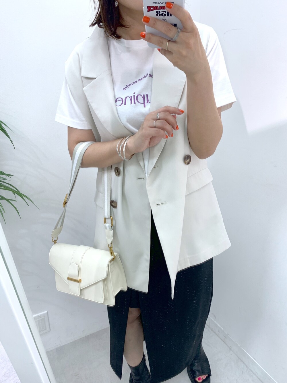 ホワイト系のベスト、ホワイト系のTシャツ/カットソー、ホワイト系のショルダーバッグを着用したレディースの春コーディネートの2枚目の写真