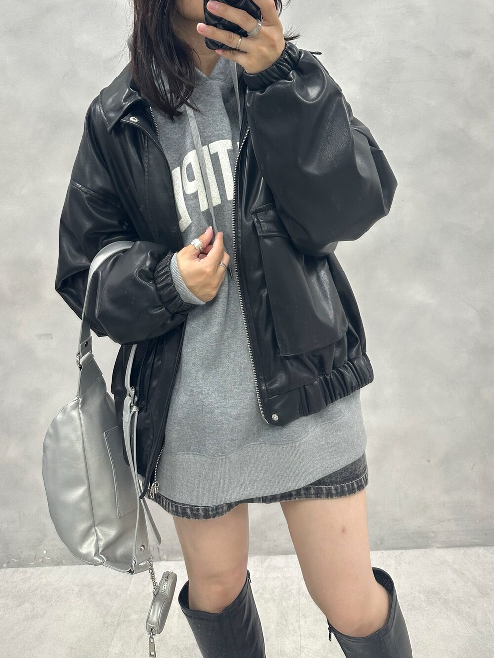 ブラック系のスカート、グレー系のパーカー、ブラック系のブルゾンを着用したレディースの秋コーディネートの2枚目の写真