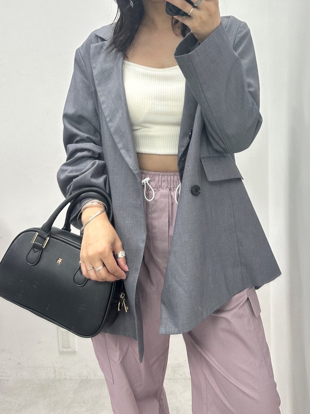 パープル系のカーゴパンツ、グレー系のテーラードジャケット、ブラック系のショルダーバッグを着用したレディースの秋コーディネートの2枚目の写真