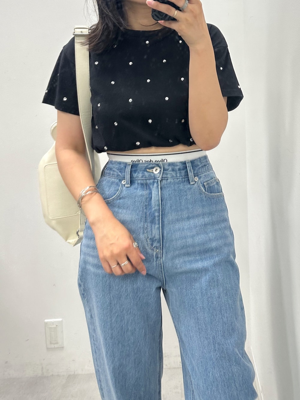 ブルー系のデニムパンツ、ブラック系のTシャツ/カットソー、ホワイト系のボディバッグ/ウエストポーチを着用したレディースの夏コーディネートの2枚目の写真