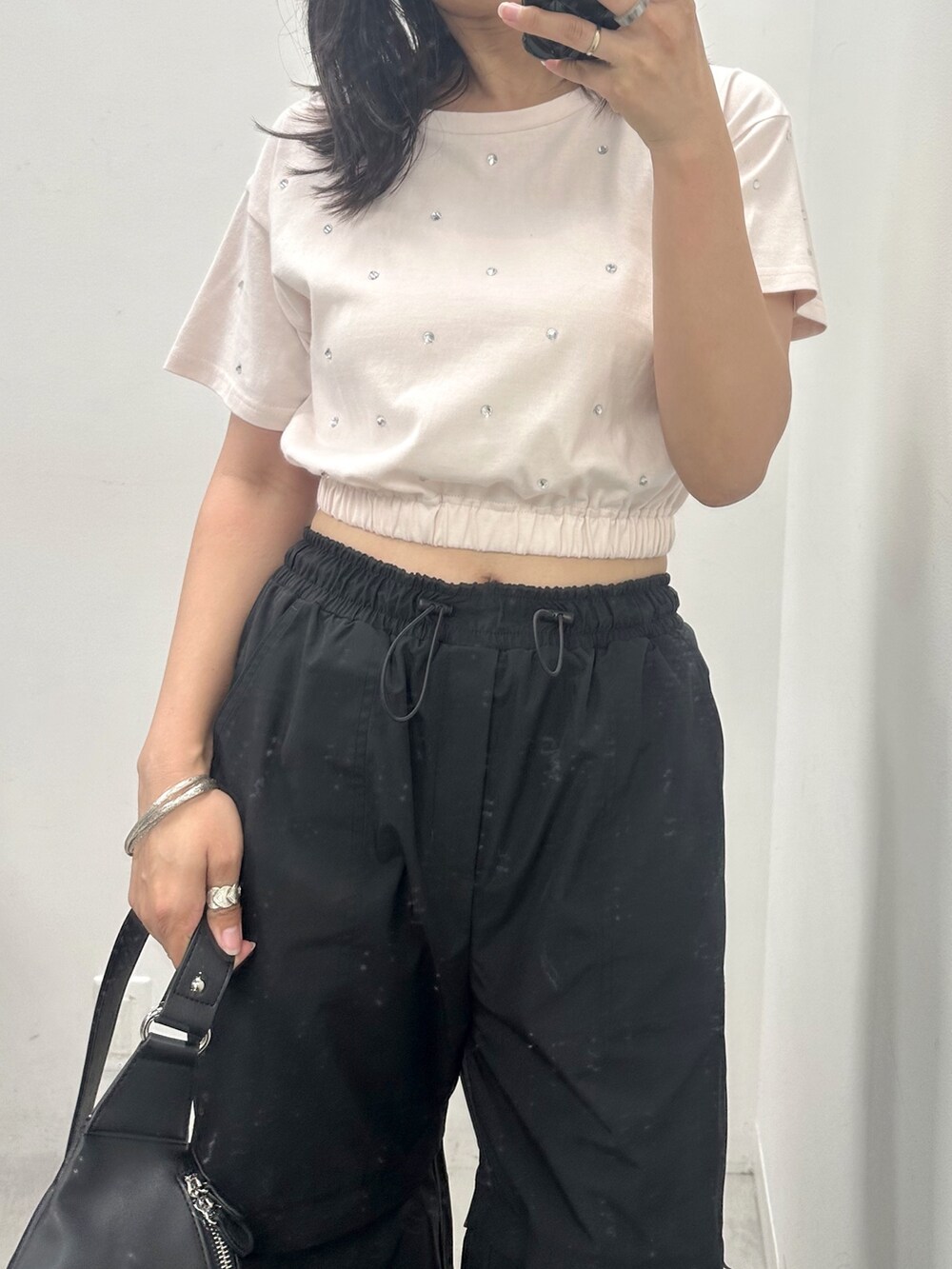ブラック系のカーゴパンツ、ピンク系のTシャツ/カットソー、ブラック系のボディバッグ/ウエストポーチを着用したレディースの夏コーディネートの2枚目の写真