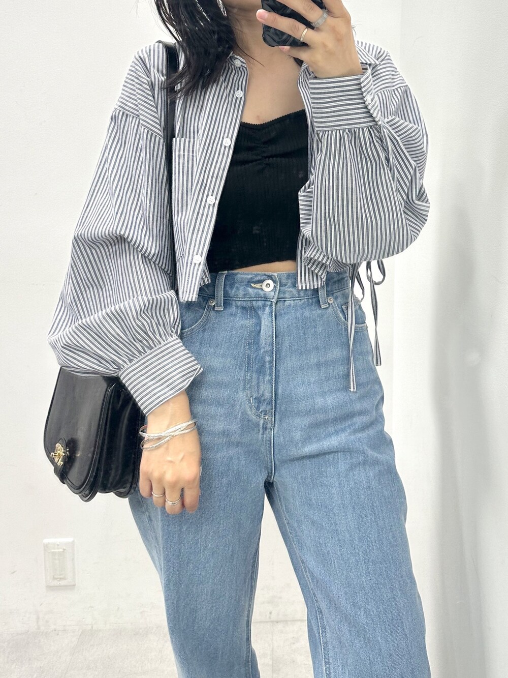 ブルー系のデニムパンツ、ブルー系のシャツ/ブラウス、ブラック系のショルダーバッグを着用したレディースの夏コーディネートの2枚目の写真