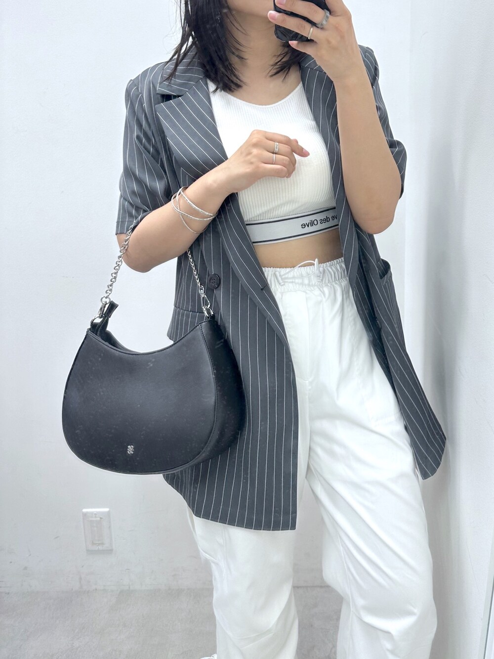 ホワイト系のカーゴパンツ、ホワイト系のタンクトップ、グレー系のテーラードジャケットを着用したレディースの夏コーディネートの2枚目の写真