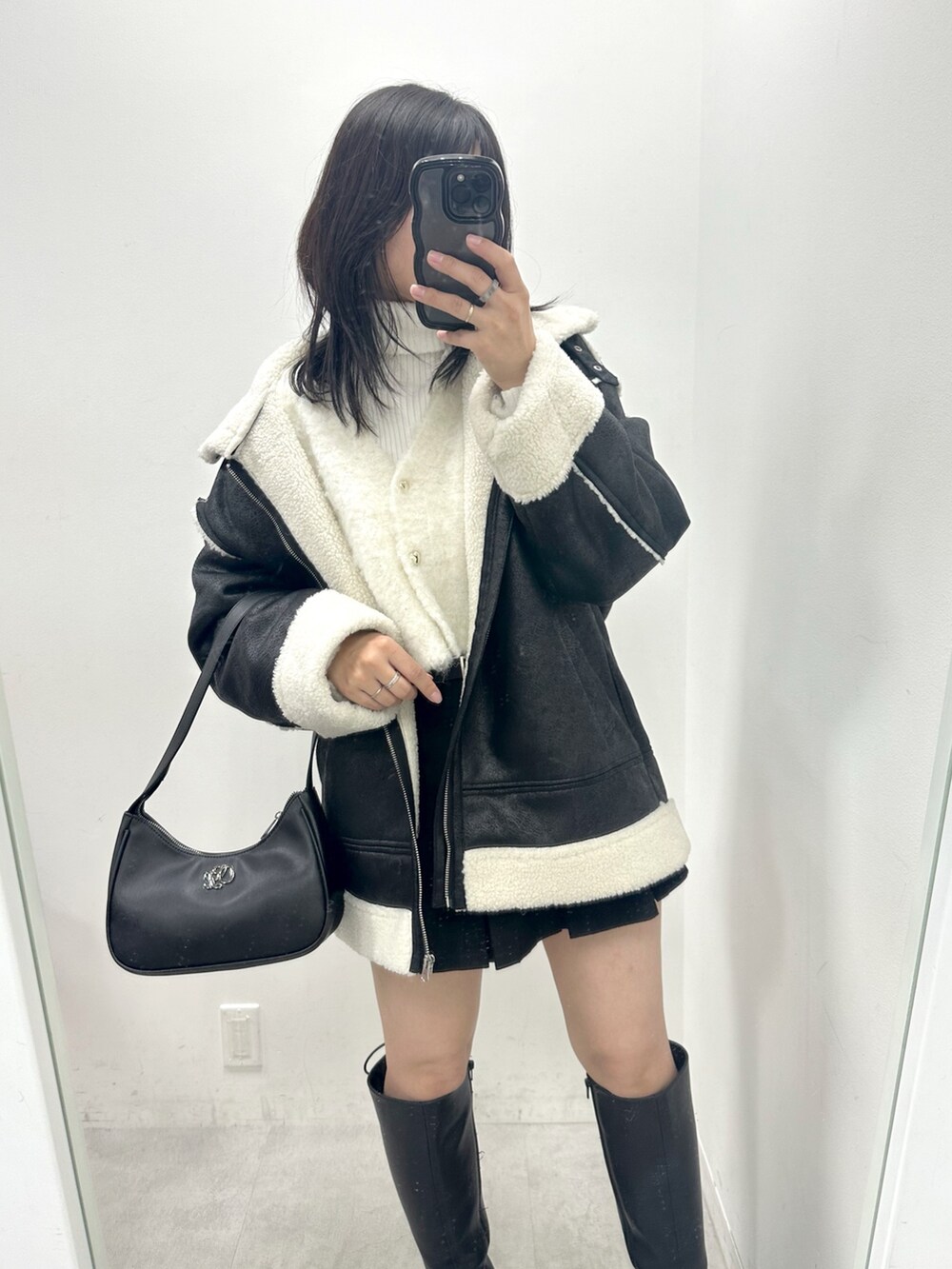 ブラック系のスカート、ホワイト系のカーディガン/ボレロ、ホワイト系のニット/セーターを着用したレディースの冬コーディネートの2枚目の写真