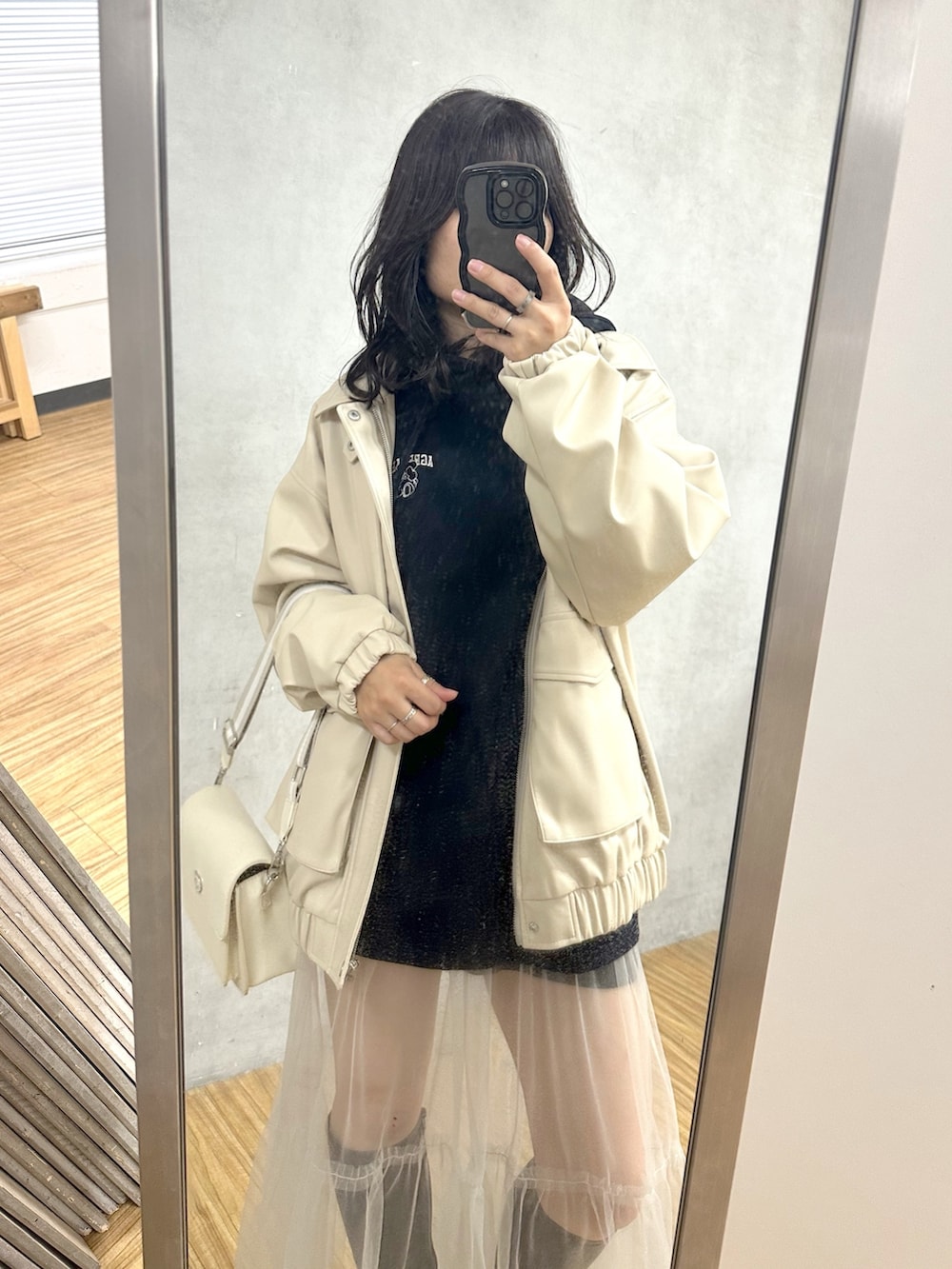 ブルー系のパーカー、ホワイト系のブルゾン、ホワイト系のショルダーバッグを着用したレディースの春コーディネートの2枚目の写真