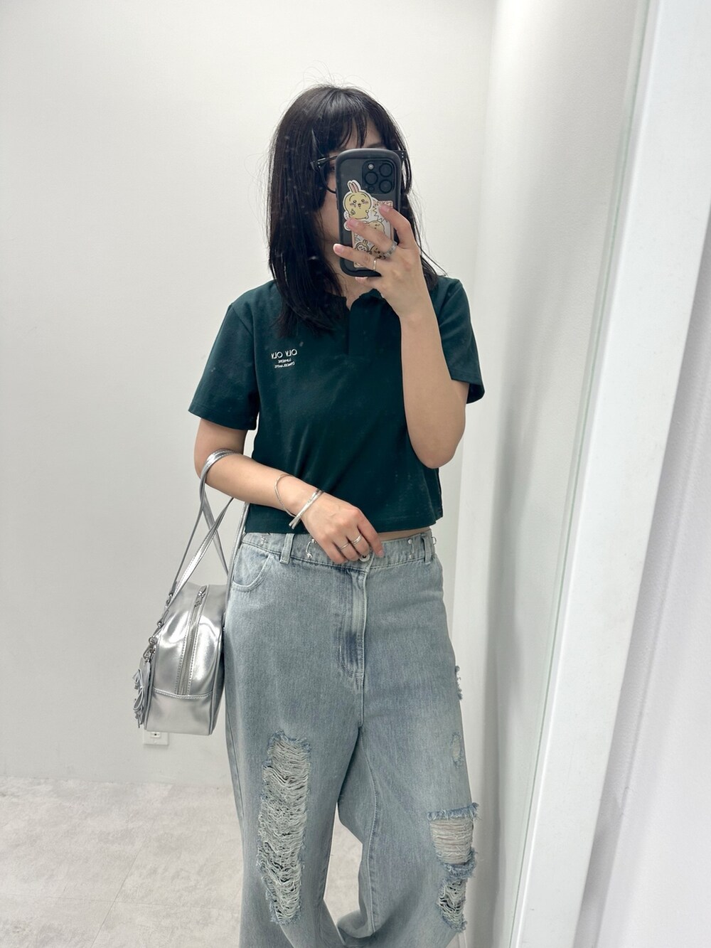 ブルー系のデニムパンツ、グリーン系のTシャツ/カットソー、シルバー系のショルダーバッグを着用したレディースの春コーディネートの2枚目の写真