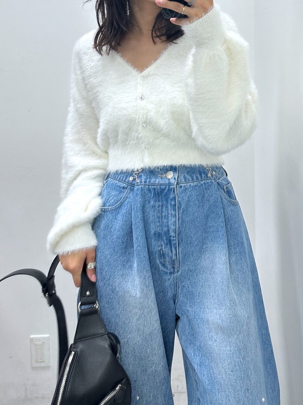 ブルー系のデニムパンツ、ホワイト系のカーディガン/ボレロ、ブラック系のボディバッグ/ウエストポーチを着用したレディースの夏コーディネートの2枚目の写真