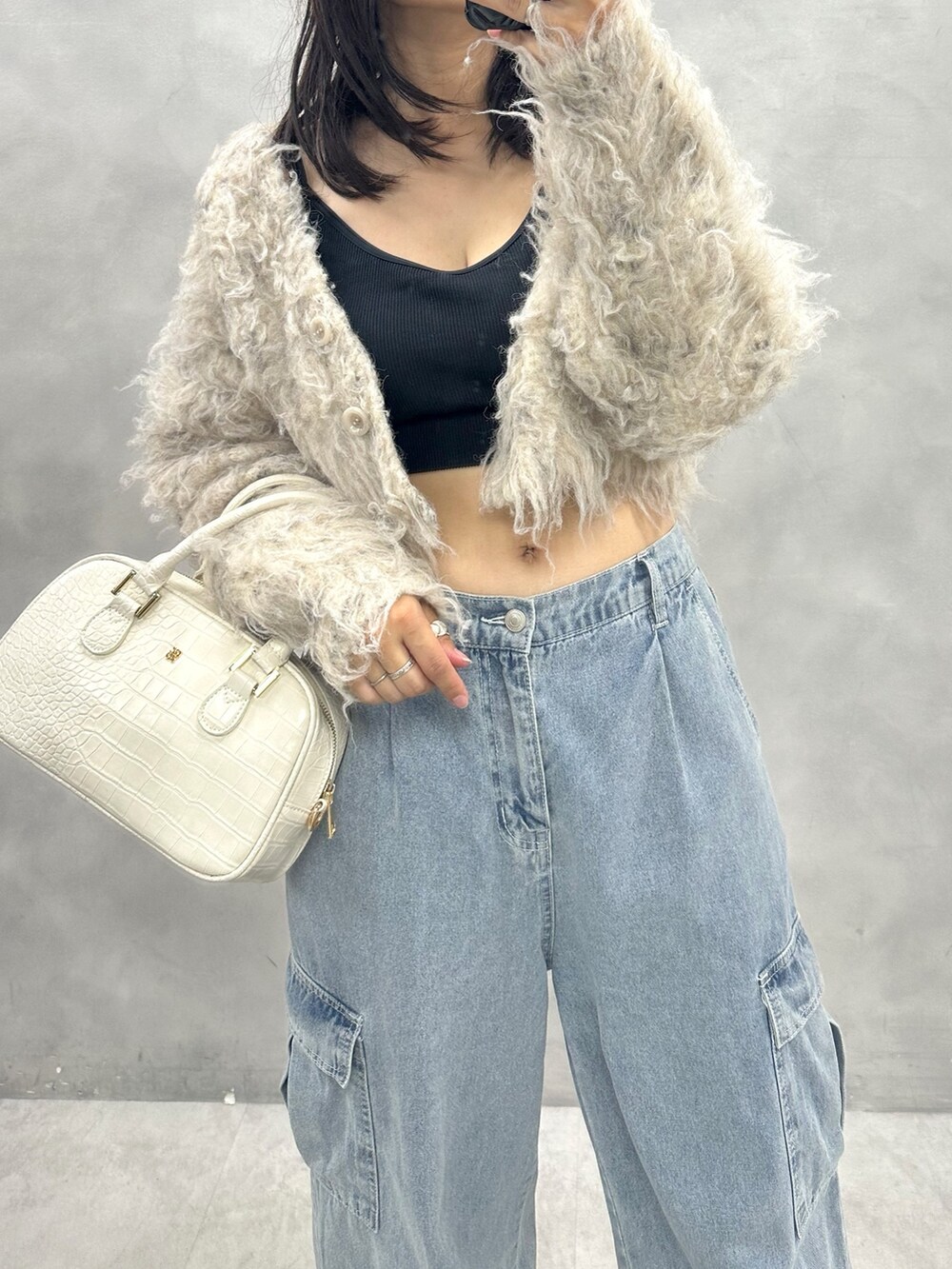 ブルー系のカーゴパンツ、ベージュ系のカーディガン/ボレロ、ホワイト系のショルダーバッグを着用したレディースの秋コーディネートの2枚目の写真